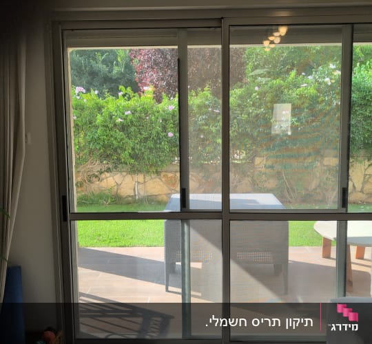 חלון זכוכית עם נוף לגינה ירוקה
